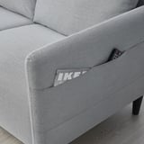 Gray sofa with side pocket holding a remote.