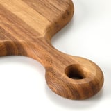 Wooden chopping board with handle, smooth and oiled finish for durability and grip.