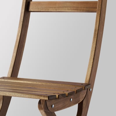 A folded wooden chair named ASKHOLMEN in light brown. Its made of durable acacia, suitable for outdoor use, and comes pre-assembled.
