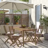 ASKHOLMEN outdoor dining set with table, 4 cushioned chairs, and umbrella on deck.
