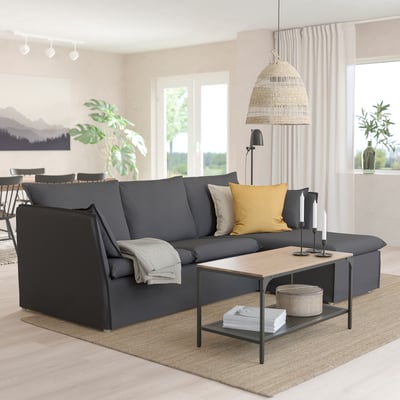 Modern living room with dark gray sofa, coffee table, pendant lamp, and window.