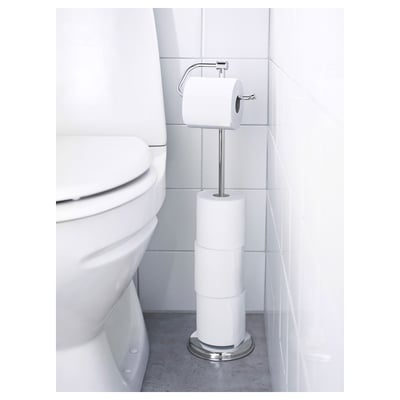 Chrome toilet paper holder with 3 rolls, magnetic fitting for easy roll change, stands beside a white toilet.