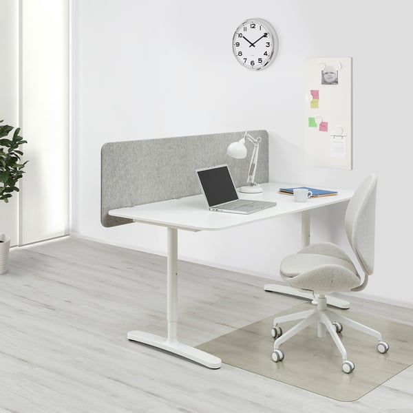 BEKANT white desk with gray screen, laptop, chair, clock, and bulletin board.