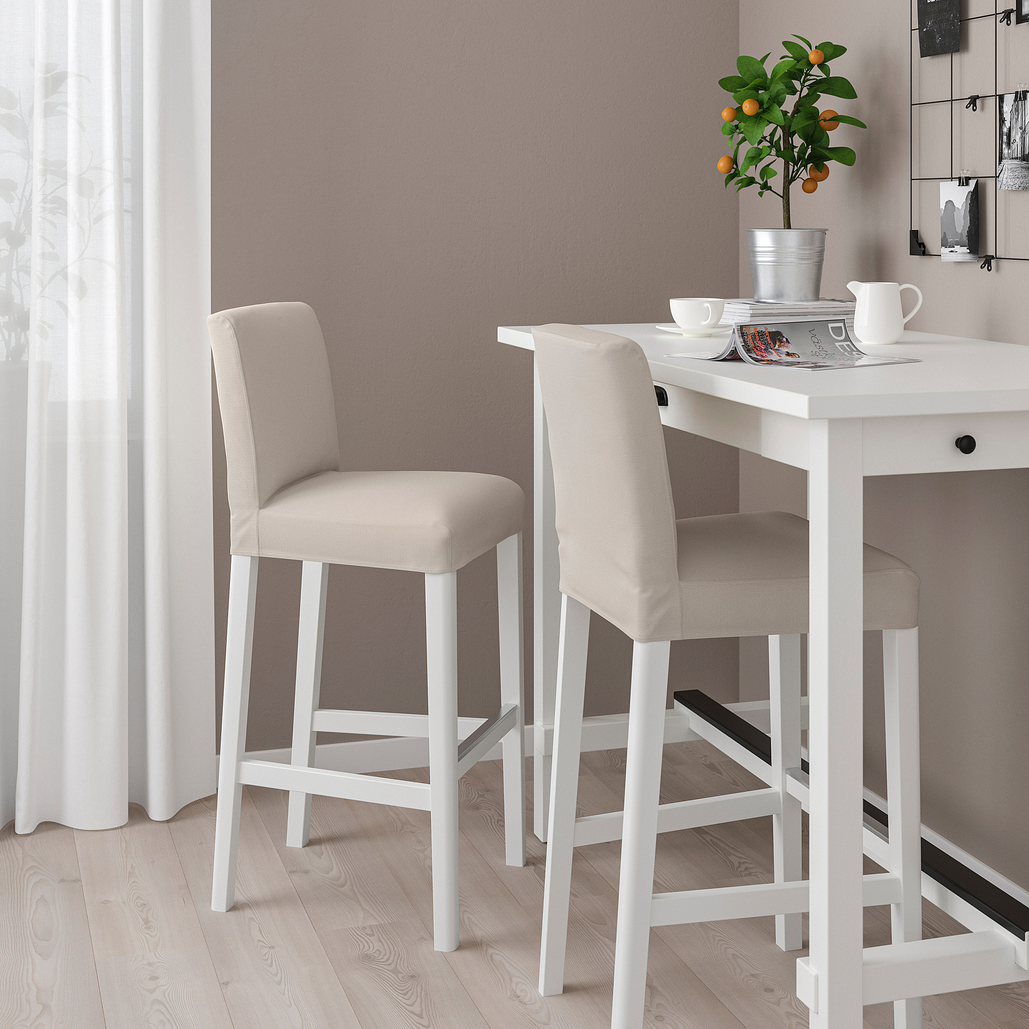 Modern dining area with white BERGMUND stools. Beige cushions, sleek design. Adult size, between curtains and table.