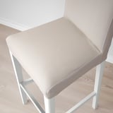 Top view of two beige bar stools with white metal legs on a wooden floor.