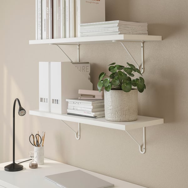 Minimalist shelves hold books, plant, and lamp, emphasizing efficient vertical space.