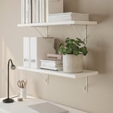 Minimalist shelves hold books, plant, and lamp, emphasizing efficient vertical space.