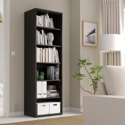 Black BESTÅ bookshelf with books and decor in modern living room.