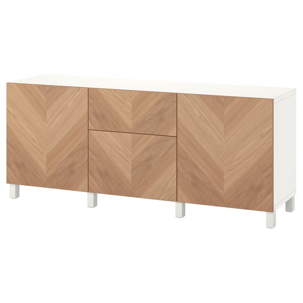 A white and wood grain sideboard, named BESTÅ, with multiple storage compartments.