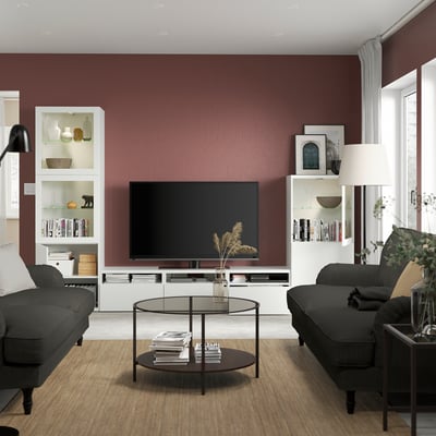White BESTÅ tv storage combo with shelves, drawers, and glass doors.