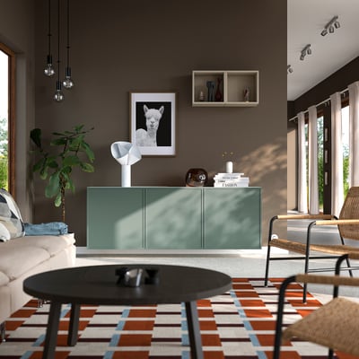 Modern living room: teal sideboard, rug, alpaca art, large windows.