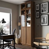 Home office with BILLY bookcase, desk, lamp, and window.