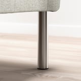 Metal leg supporting a fabric-covered furniture base, likely part of a bed frame.