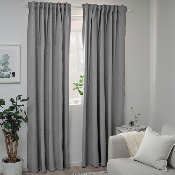 Modern room with BLÅHUVA dark gray curtains, white couch, and potted plant. Curtains are floor-length.