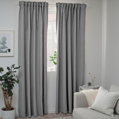 Modern room with BLÅHUVA dark gray curtains, white couch, and potted plant. Curtains are floor-length.