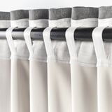 Curtain rod with hanging hooks. The hooks attach curtains to block light and ensure privacy.