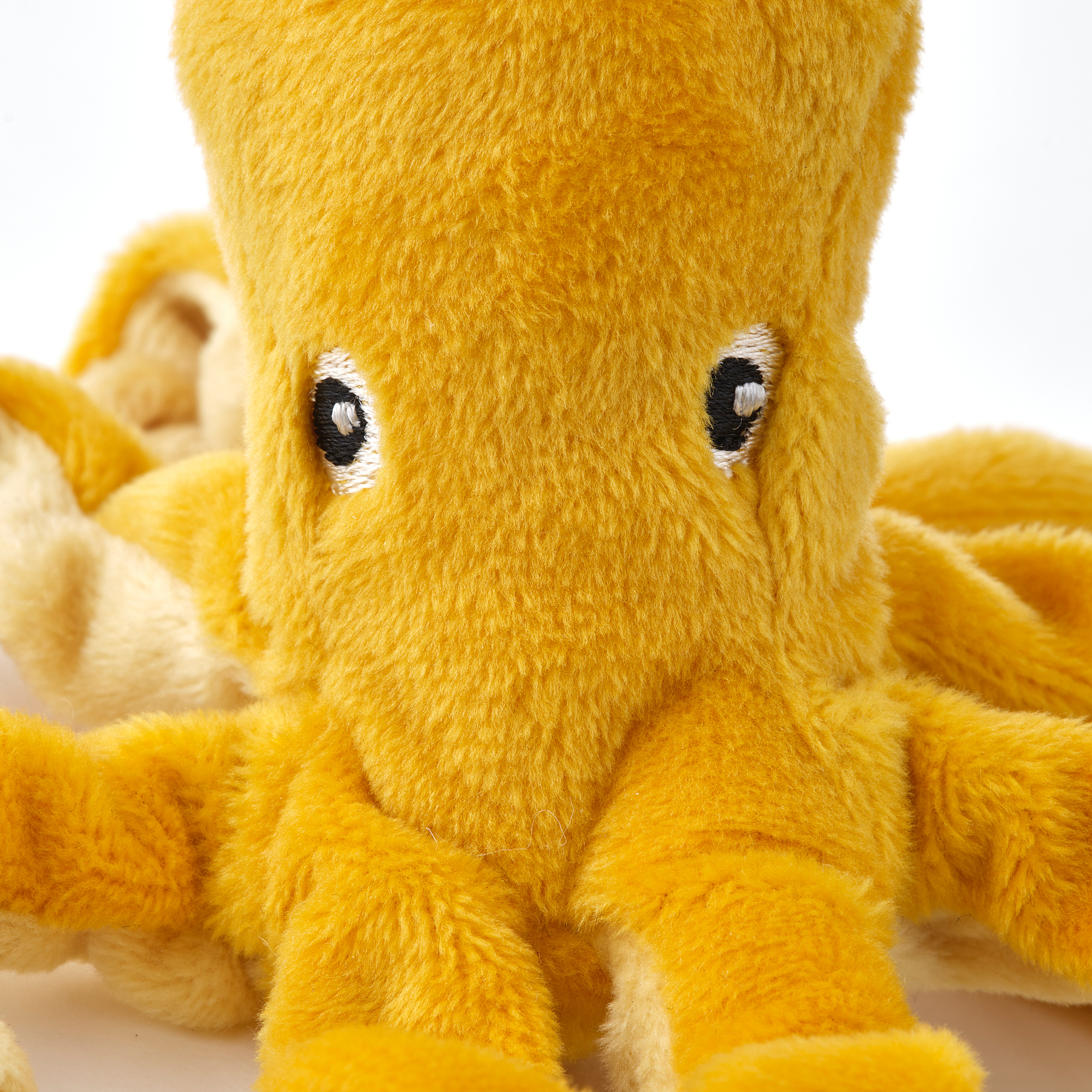 Soft toy octopus with embroidered eyes, plush yellow texture, and detailed tentacles, perfect for cuddling.
