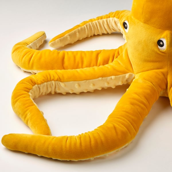 Plush toy octopus with woven body, textured sucker arms, embroidered eyes, showcasing detailed craftsmanship.