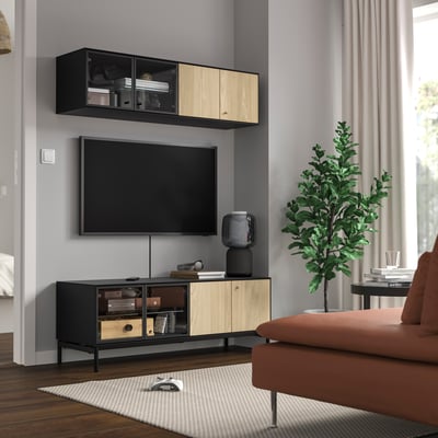 Modern living room with BOASTAD tv bench & shelf, large orange couch, green plant, and stylish decor.
