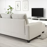 Modern living room with gray sectional sofa, ottoman, and tv.