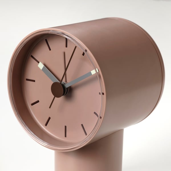 Pastel pink minimalist alarm clock with dark grey hands.