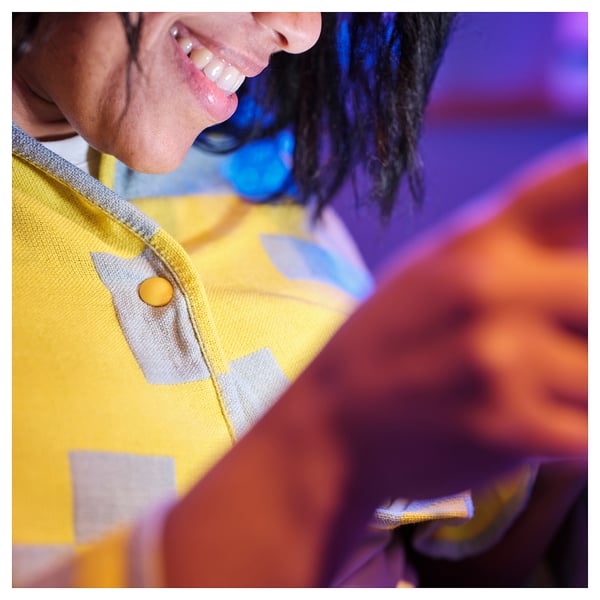 Close-up of a cozy, pixel-patterned throw blanket in bright yellow. Feels soft and warm, perfect for a gaming night.