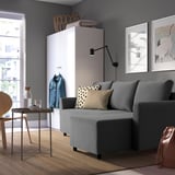 Modern living room with gray BRISSUND sofa-bed. Its large, fits well in space, beside a white cabinet and framed art.