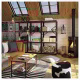 Cozy living room with black BROR bookshelves, leather orange sofa, striped rug.