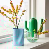 Blue, green, & clear vases: one large blue with branches & berries, plus a cactus & clear curved vase.