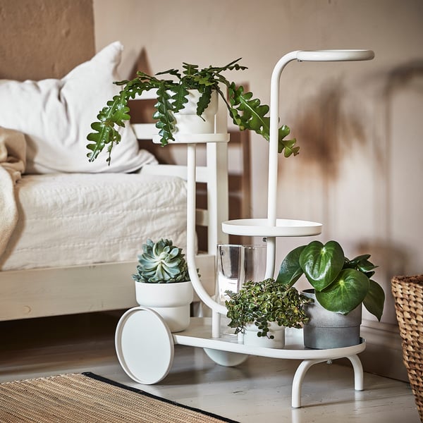 CHILISTRÅN plant stand with potted plants near bed.