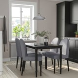A sleek DANDERYD dining set in grey with modern upholstered chairs and a sturdy black table, perfectly complementing the kitchen decor.