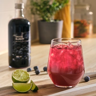 A bottle of ikea blueberry drink concentrate, 485 ml, dark blue liquid, glass bottle with a metallic cap.