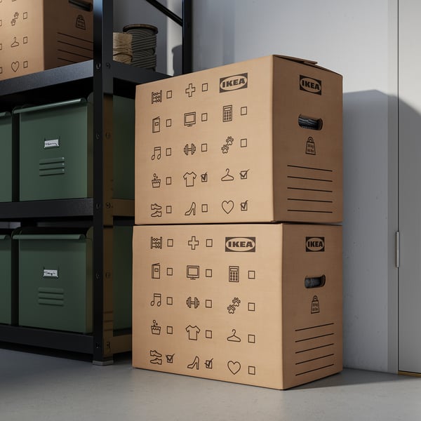 Two stacked ikea storage boxes with symbols on them near metal shelves.