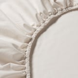 Close-up of white elastic sheeting, showcasing soft, durable cotton with fine yarn details.