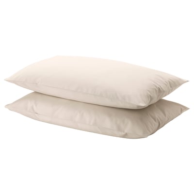 Two light beige rectangular pillows stacked neatly. Simple, smooth design. Made from natural cotton.