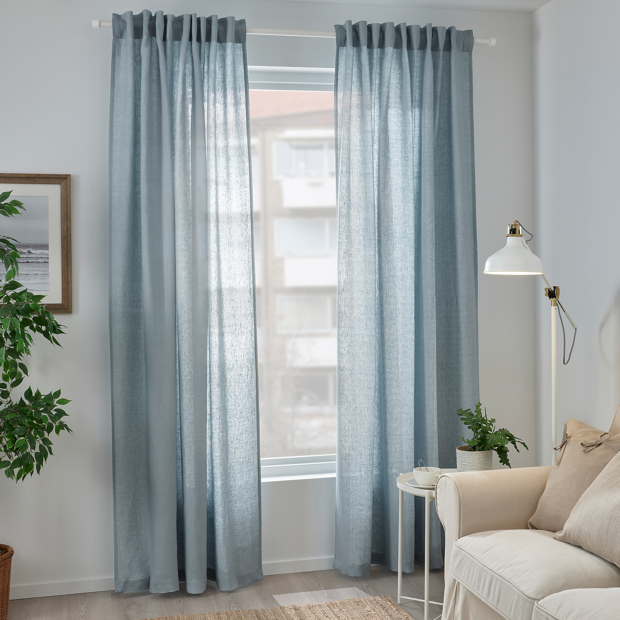 Timeless grey-blue DYTÅG linen curtains hang beside a white chair. Their eclectic texture.