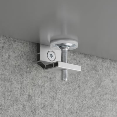 Metal clamp mounted on textured gray surface, securing a round metal piece with a threaded bolt.