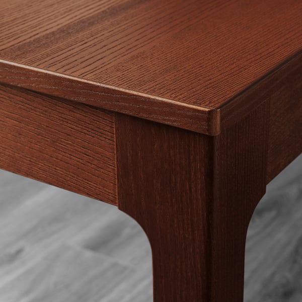 Close-up of polished brown wood table edge, showcasing smooth finish and solid craftsmanship.