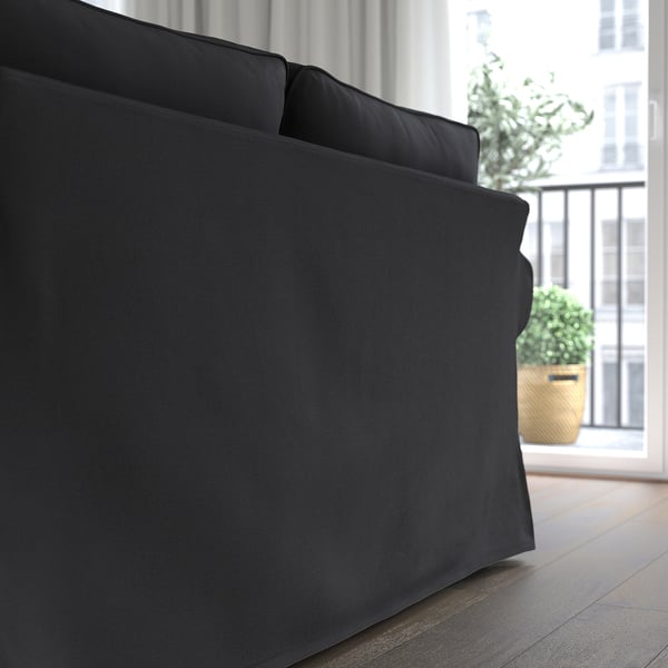 A black EKTORP sofa with thick cushions. The chaise longue can be positioned on either side.
