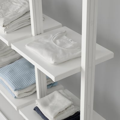 White shelves with folded clothes and a shirt, mounted using ELVARLI brackets.