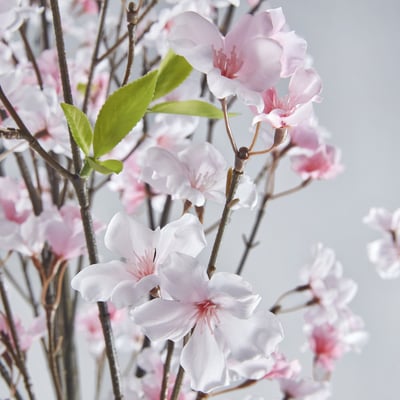 Artificial cherry tree with pink/white flowers, indoor decor.