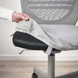 Person adjusting ergonomic office chair, FLINTAN model, featuring mesh back and removable seat cover.