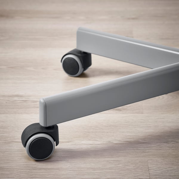 Close-up of grey ergonomic office chairs castor on light wooden floor. Shows smooth, durable design.