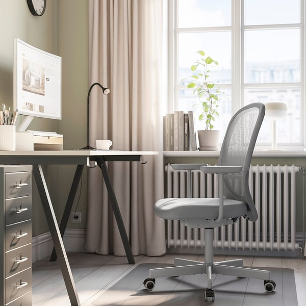 Modern home office with ergonomic chair, desk, pc, lamp, plant, bookshelf.