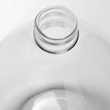 Clear glass vase, mouth blown, showcasing craftsmanship, placed on smooth white surface.