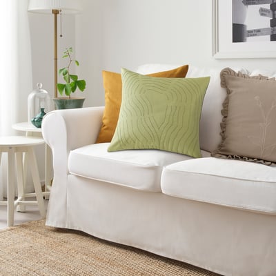 Light green FRÖDD cushion with swirls on white couch.