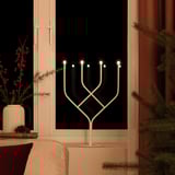 Led candelabra with warm white light, creating cozy atmosphere, on table in living room.