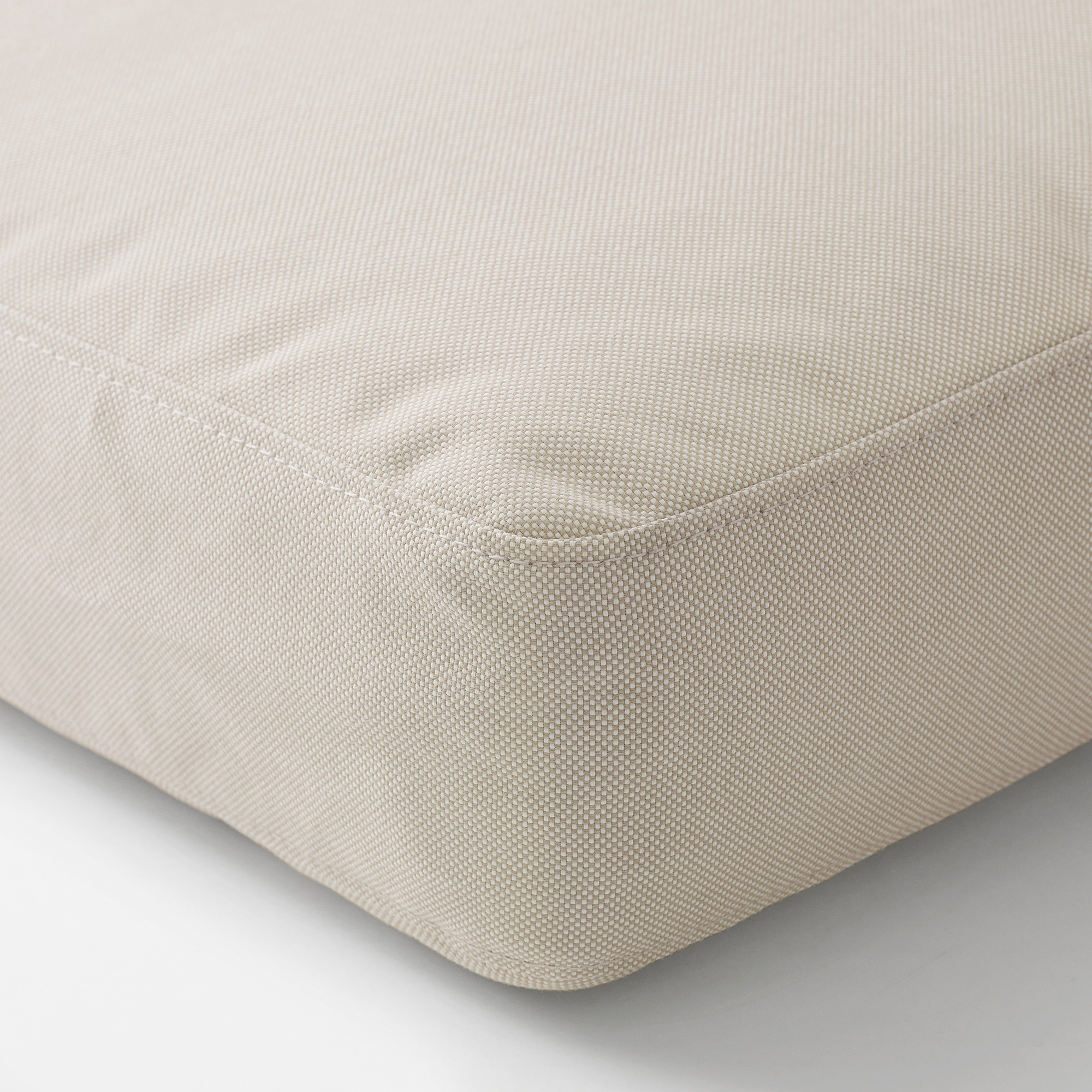 Soft, rectangular outdoor cushion with smooth, beige fabric, showcasing high-quality stitching and a plush, even surface.