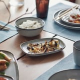Dining table with gray stoneware, rice, grilled veggies, chopsticks.