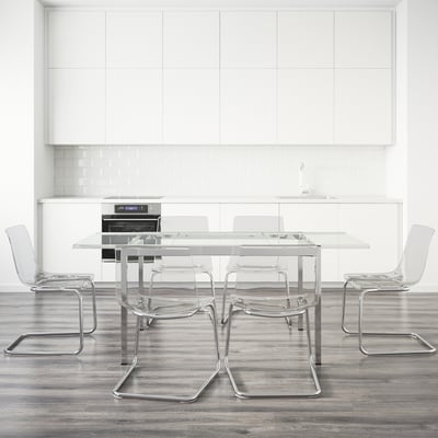 Glass table with four matching chairs, ideal for small spaces.